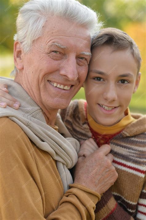 Premium Photo Grandfather And Grandson Hugging In Park