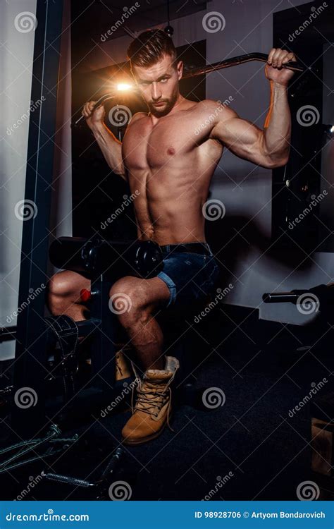 muskulöse bodybuildergutaussehende männer die Übungen in der turnhalle mit dem nackten torso