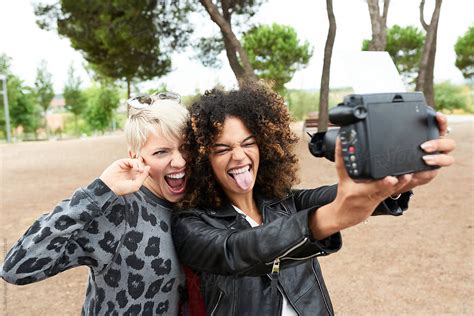 Girls Taking Selfie With Polaroid And Smiling By Stocksy Contributor