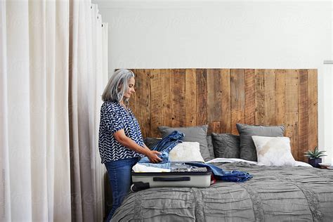 Mature Woman Packing A Suitcase In Her Bedroom By Stocksy Contributor Trinette Reed Stocksy