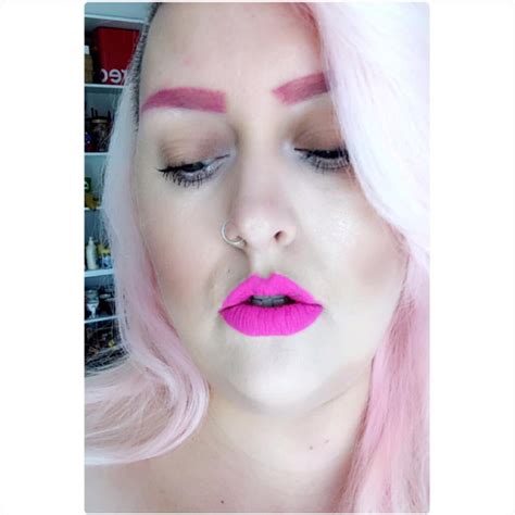 A Woman With Pink Hair And Makeup Has Her Eyes Closed To The Side While She S Wearing Bright