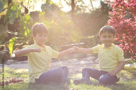 Niños Felices Jugando A Chocar Los Puños En El Jardín Al Atardecer Foto