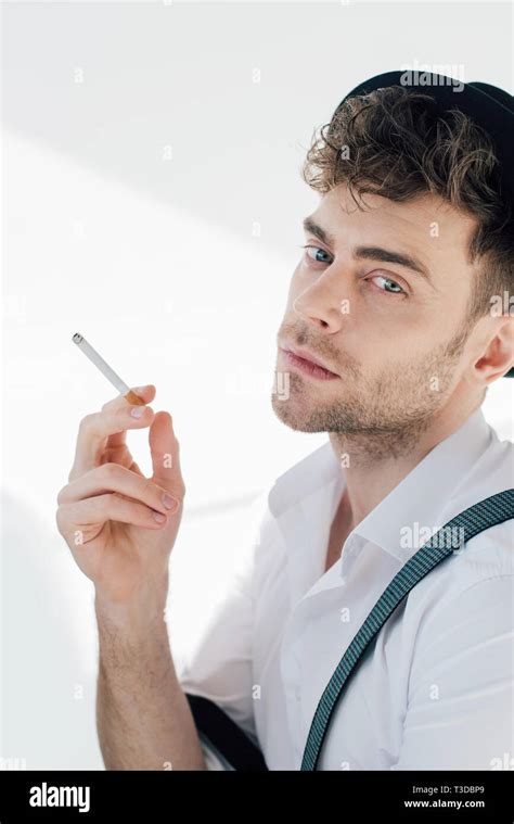 Handsome Man Holding Cigarette And Looking At Camera Stock Photo Alamy