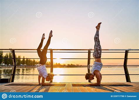 Couple Practicing Acrobatic Yoga Together Doing Handstand Pose On