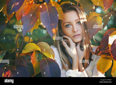 Portrait Of Beautiful Young Woman Posing By Rose Bush Stock Photo Alamy