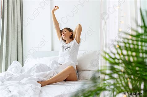 Mujer Está Despertando En La Cama En Su Dormitorio Foto De Stock