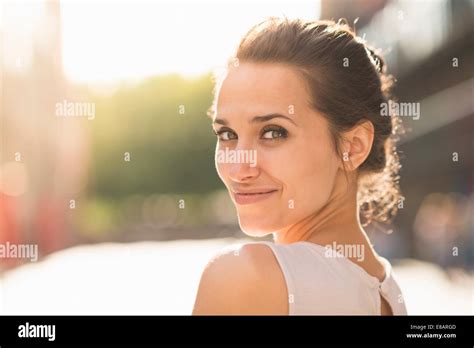 Young Woman Looking Over Shoulder Towards Camera Stock Photo Alamy