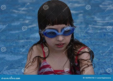 Girl With Protective Goggles And Red Swimsuit Splashing In Swimming