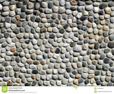 Stone Wall Made Of Oval Shape Pebbles Of Various Colors Close Up