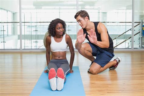 Personal Trainer Working With Client On Exercise Mat Stock Image