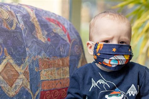 Portrait Of Angry Baby With Reusable Protective Face Mask Stock Image