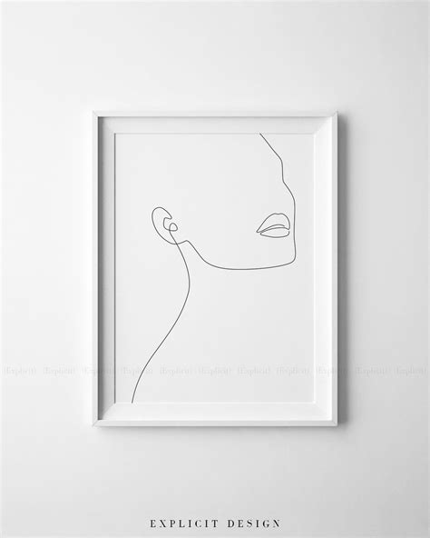 A Minimal Line Drawing Of A Woman S Face In A White Frame On The Wall