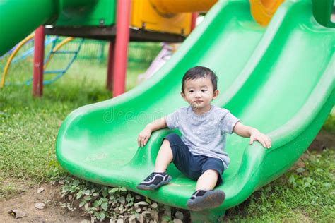 Little Asian Kid Playing Slide At The Playground Stock Photo Image Of