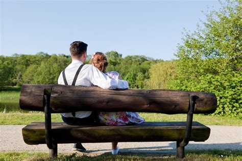 Jeunes Couples Dans Lamour Embrassant Sur Un Banc En Parc Cru Photo