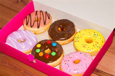 Six Colored Donuts In A Pink Box On A Wooden Background Sweet D Stock