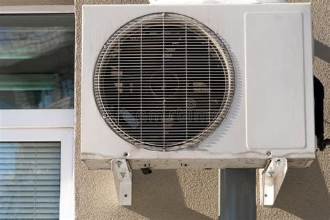 An Outdoor Air Conditioner Unit Installed On The Outer Wall Of A