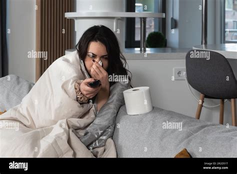 Ill Upset Young Woman Sitting On Sofa Covered With Blanket Freezing