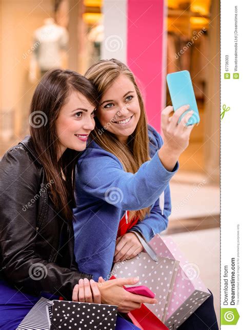 two beautiful women taking a selfie in shopping mall stock image image of cheerful happy