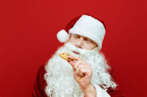Premium Photo Portrait Man Dressed As Santa Claus Eating Chocolate Chip