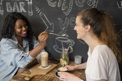 Two Friends Meeting In Cafe Sharing Coffee Stock Photo