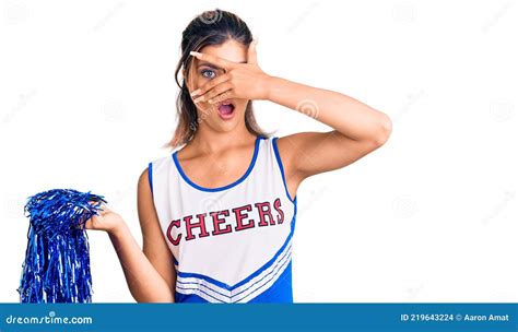Young Beautiful Woman Wearing Cheerleader Uniform Peeking In Shock Covering Face And Eyes With