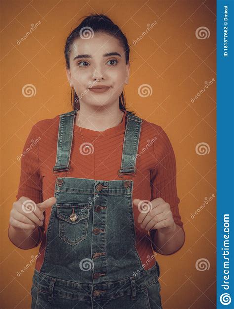 Beautiful Girl Model In A Red Sweater And Blue Overalls Posing Stock