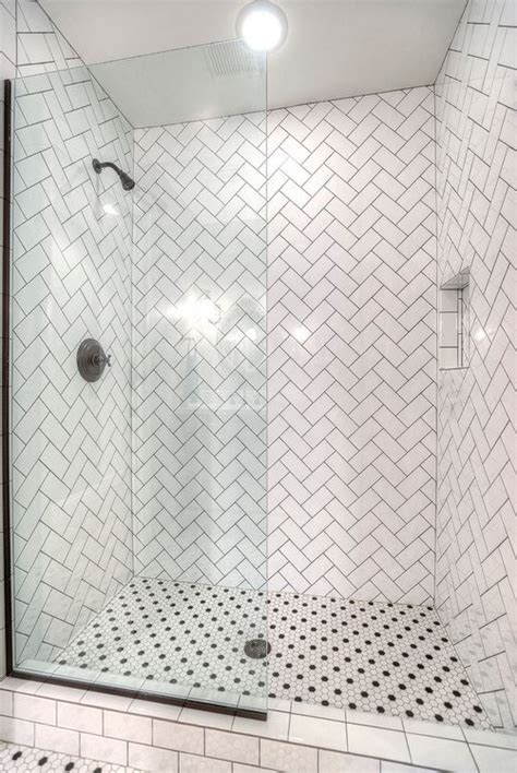 A White Tiled Shower With Black And White Tile