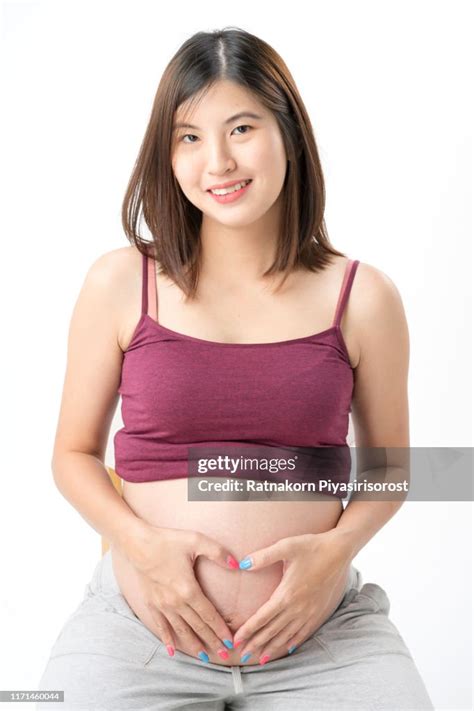 pregnant concept beautiful asian pregnant woman with her hand on the pregnant belly and sitting