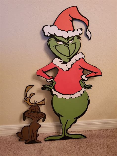 A Cardboard Cutout Of The Grinch And His Reindeer Is Standing Next To