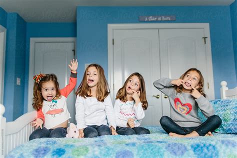 A Group Of Young Girls Making Funny Faces While Sitting On A Bed Del