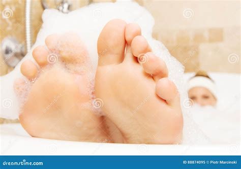 Closeup Of Woman`s Feet Covered With Foam Bubble Bath Stock Image