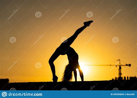 Female Gymnast Showing Her Flexibility And Split During Sunset On