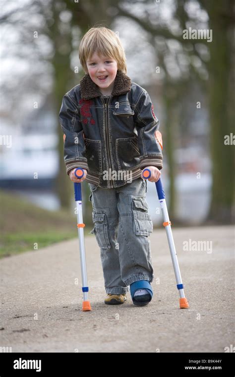 Little Boy With A Broken Leg Walking With Crutches Stock Photo
