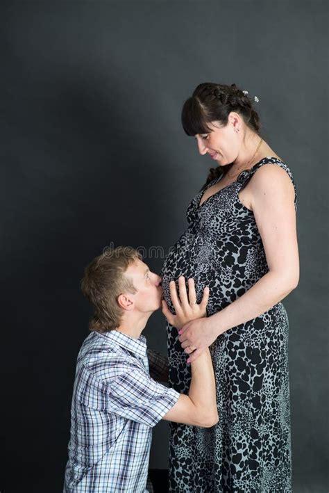 Pregnant Brunette Woman With Husband On Red Background Couple Stock