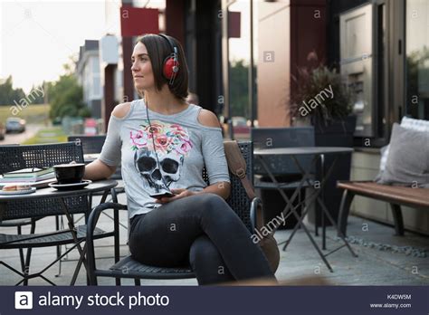 Brunette Woman With Headphones Listening To Music And Drinking Coffee