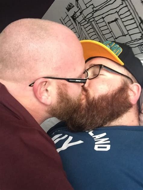 A Man With Glasses And A Beard Is Leaning Against Another Man S Head To