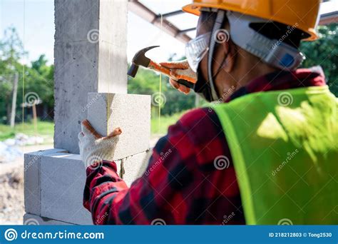 Close Up Of Bricklayer Builder Use A Hammer To Help With Autoclaved