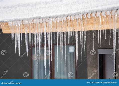 Icicles Hang From The Snowy Roof Of A Mountain Cottage Stock Image