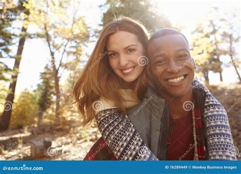 Happy Mixed Race Couple Embracing During Hike In A Forest Stock Image