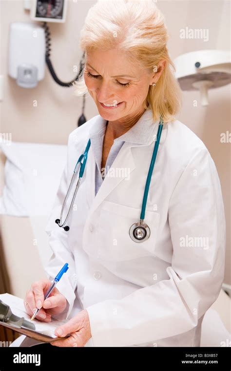Middle Aged Female Doctor Writing On A Clipboard Stock Photo Alamy