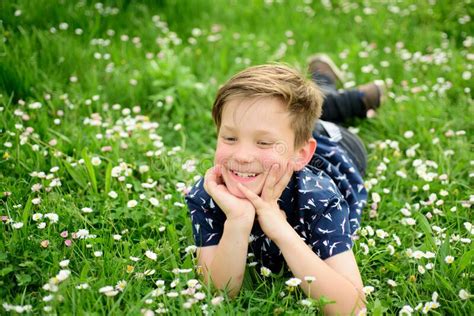 Carefree Smiling Boy Lying On Flower Field Cute Kid Child Enjoying On