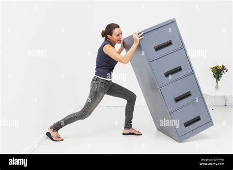 Woman Struggles With Filing Cabinet Stock Photo Alamy