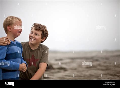 Boy Comforting His Crying Younger Brother On Beach Stock Photo Alamy