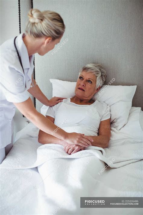Female Doctor Interacting With Senior Patient At Home — Senior Citizen