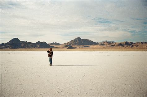 Young Male Stands In Desert With Long Shadow By Stocksy Contributor