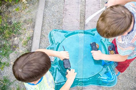 Two Boys Playing With A Spinning Top Kid Toy Popular Children Game