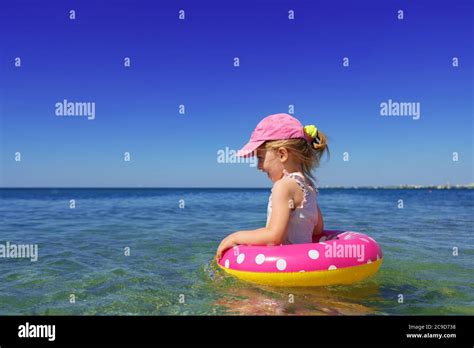 Kleines Mädchen im Bikini Schwimmen im Meer mit Schwimmkreis Stockfotografie Alamy