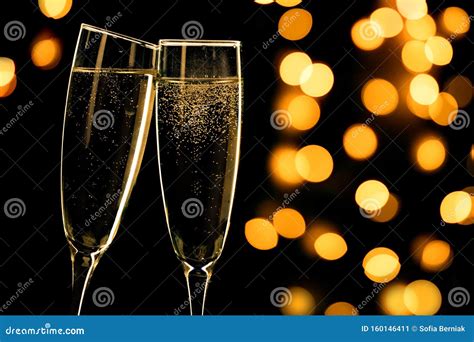 Two Champagne Glasses Toasting On Black Background With Bokeh Lights
