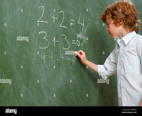 Boy Writing On Blackboard Stock Photo Alamy