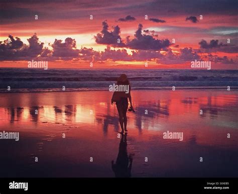 Girl Walking Into The Ocean Sunset Stock Photo Alamy